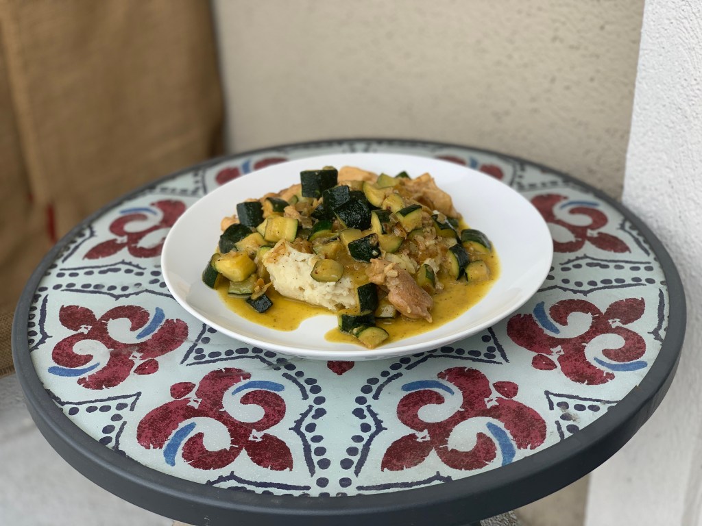 chicken and zucchini dish served over mashed potatoes
