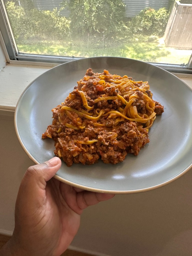 Spaghetti with meat sauce pictured by a window 